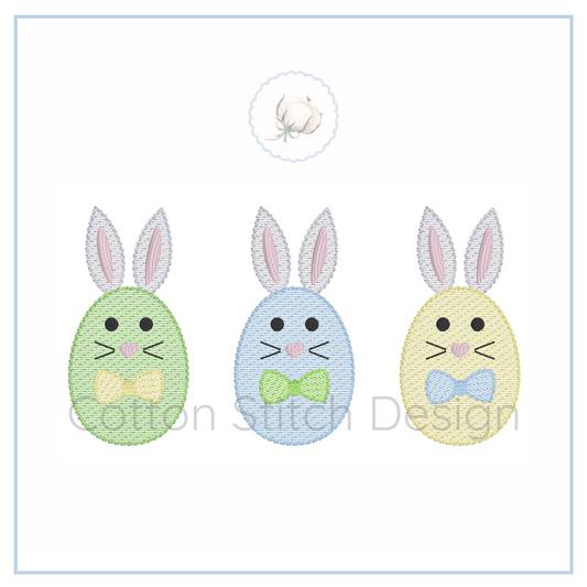 Machine Embroidery design Cotton Stitch Designs Three embroidered Easter eggs with bunny faces and colorful bow ties on a white background.