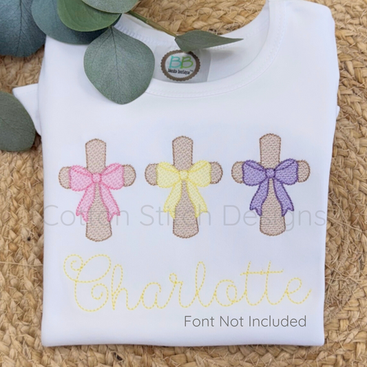 Machine Embroidery design Cotton Stitch Designs Folded white shirt with embroidered crosses and bows on a woven surface