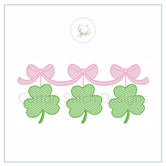 Machine Embroidery design Cotton Stitch Designs Three green shamrock leaves with pink bows on a white background