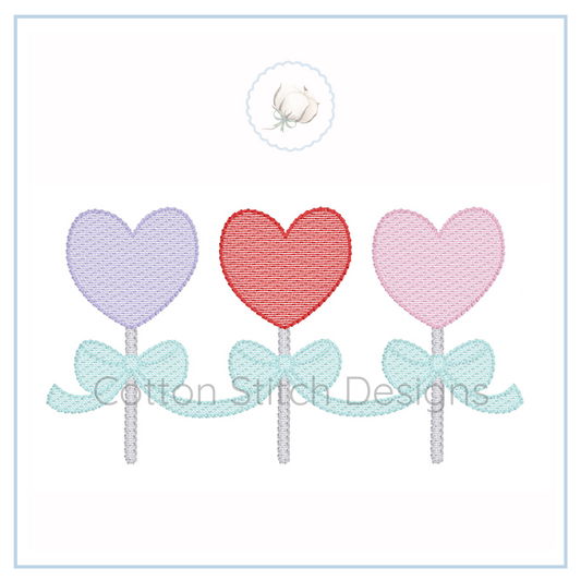 Machine Embroidery design Cotton Stitch Designs Three heart-shaped lollipops with bows on sticks, embroidered design.
