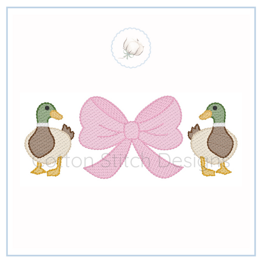 Machine Embroidery design Cotton Stitch Designs Two embroidered ducks flanking a pink bow on a white background