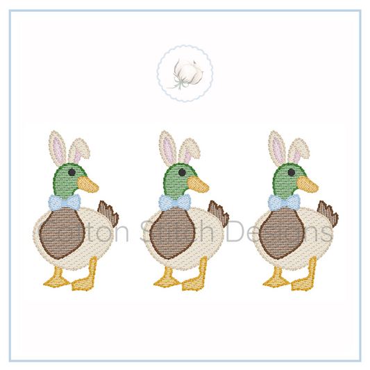 Machine Embroidery design Cotton Stitch Designs Three embroidered ducks with bunny ears and bow ties on a white background