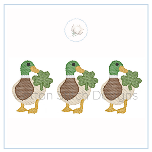 Machine Embroidery design Cotton Stitch Designs Three cartoon ducks holding clover leaves on a white background