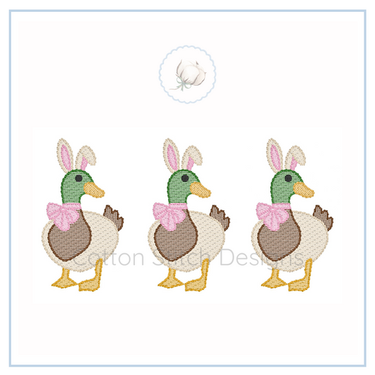 Machine Embroidery design Cotton Stitch Designs Three cartoon ducks with bunny ears and pink bows on a white background