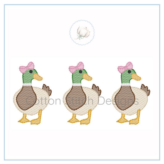 Machine Embroidery design Cotton Stitch Designs Three embroidered ducks with pink bows on a white background