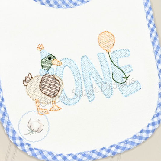 Machine Embroidery design Cotton Stitch Designs Embroidered bib with duck design and 'ONE' text on a blue checkered border.