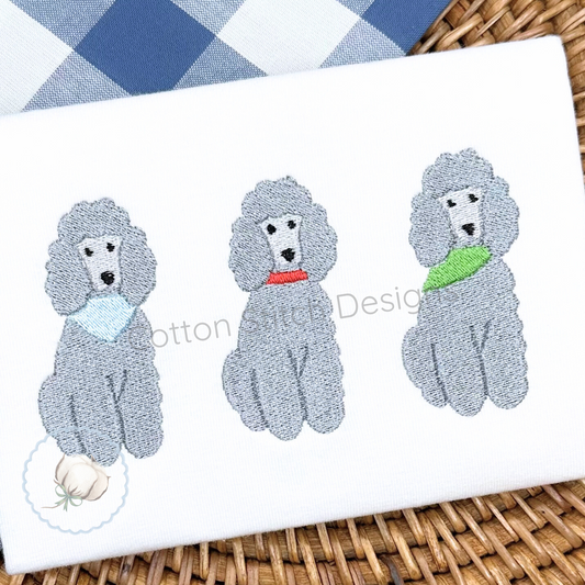 Machine Embroidery design Cotton Stitch Designs Three gray poodle-shaped bath towels with colorful collars on a white towel with 'Cotton Buds Design' branding.