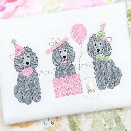 Machine Embroidery design Cotton Stitch Designs Embroidered design of three poodles with party hats and balloons on a white fabric background.