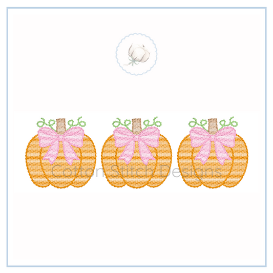 Machine Embroidery design Cotton Stitch Designs Three embroidered pumpkins with pink bows on a white background.