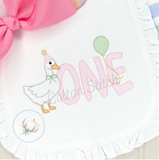 Machine Embroidery design Cotton Stitch Designs Baby bib with duck design and 'ONE' embroidery, featuring a pink bow.