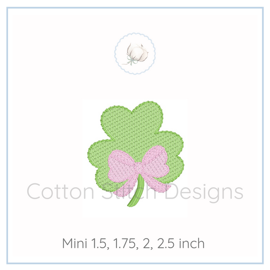 Machine Embroidery design Cotton Stitch Designs Four-leaf clover with a pink bow on a white background, branded 'Cotton Scroll Designs'.